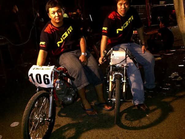 Dua rider tim NGM berpose dengan motornya, nomor start 106